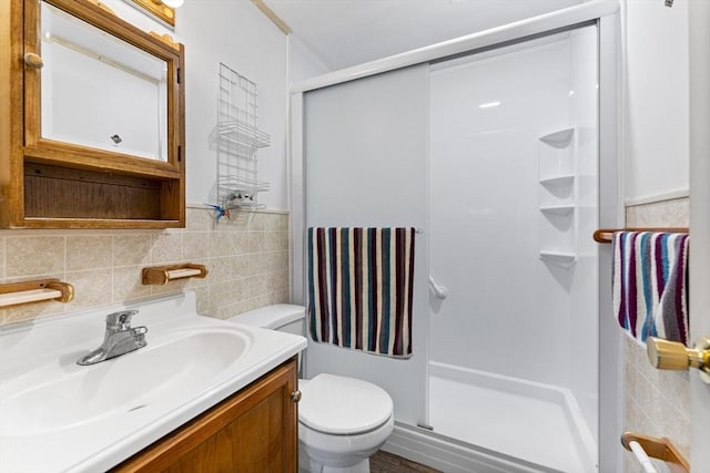 bathroom featuring toilet, a stall shower, tile walls, and vanity