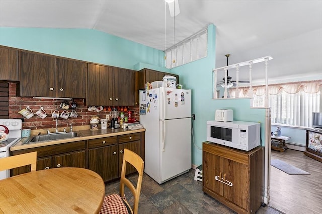 kitchen featuring dark brown cabinetry, white appliances, ceiling fan, vaulted ceiling, and a sink