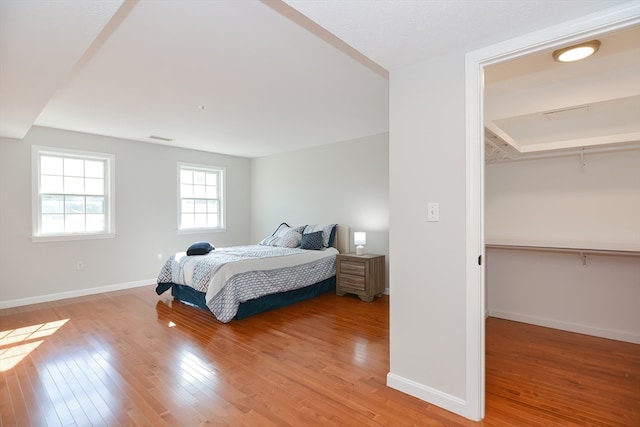 bedroom featuring light hardwood / wood-style flooring and a walk in closet