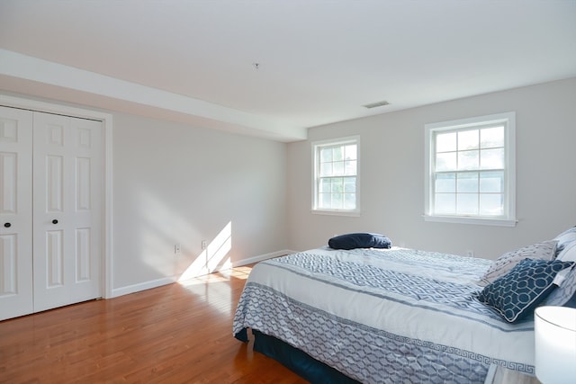 bedroom with wood-type flooring and a closet