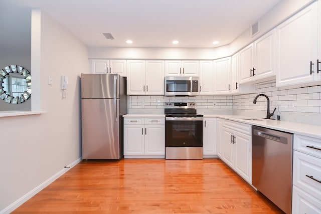 kitchen featuring light wood-type flooring, white cabinetry, sink, and stainless steel appliances