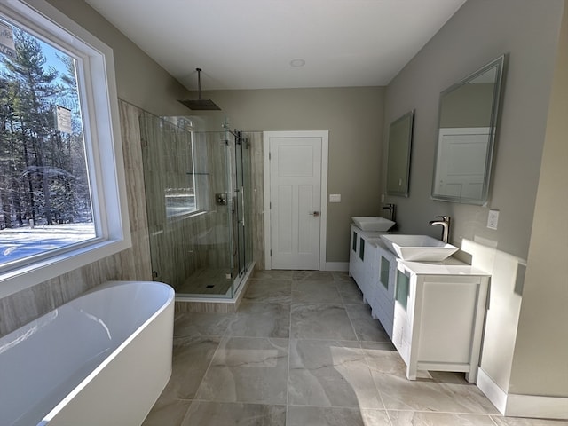 bathroom featuring vanity, separate shower and tub, and a wealth of natural light