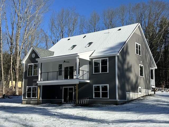 snow covered property featuring ceiling fan and a balcony