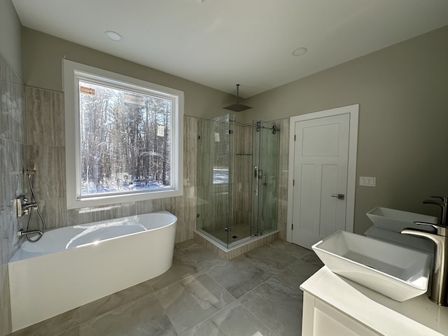 bathroom with vanity, separate shower and tub, and plenty of natural light