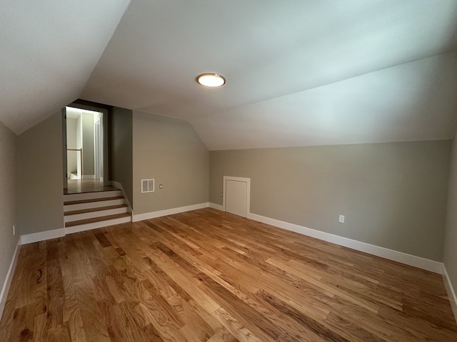 additional living space featuring light hardwood / wood-style flooring and lofted ceiling