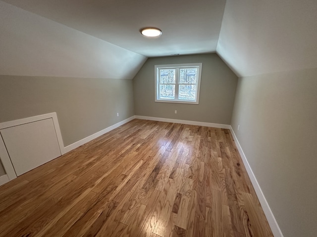 additional living space featuring light hardwood / wood-style floors and lofted ceiling