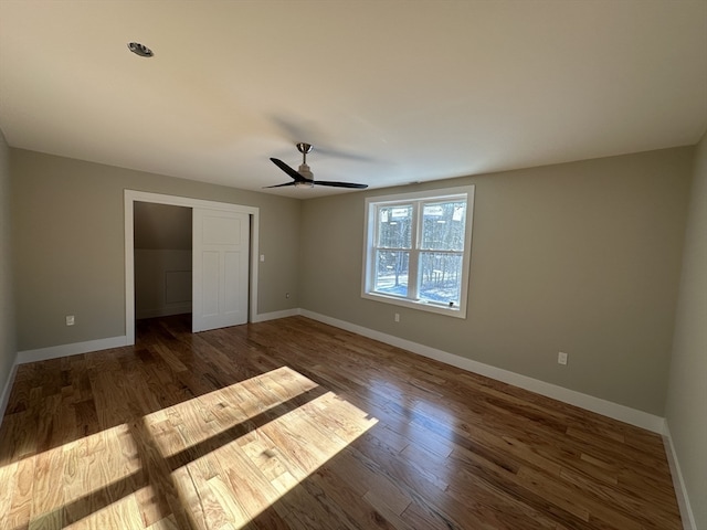 unfurnished bedroom featuring ceiling fan, dark hardwood / wood-style floors, and a closet