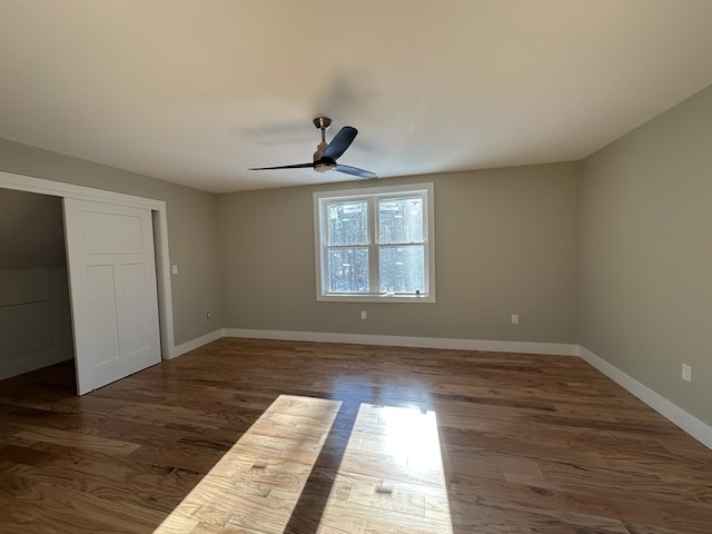 unfurnished bedroom with ceiling fan and dark wood-type flooring