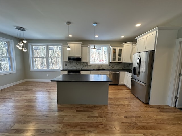 kitchen featuring decorative light fixtures, white cabinetry, and appliances with stainless steel finishes