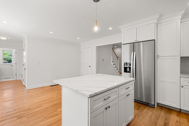 13 River Unit 2, Danvers, MA 01923 - kitchen featuring stainless steel refrigerator with ice dispenser, ornamental molding, light wood-style floors, a kitchen island, and white cabinets