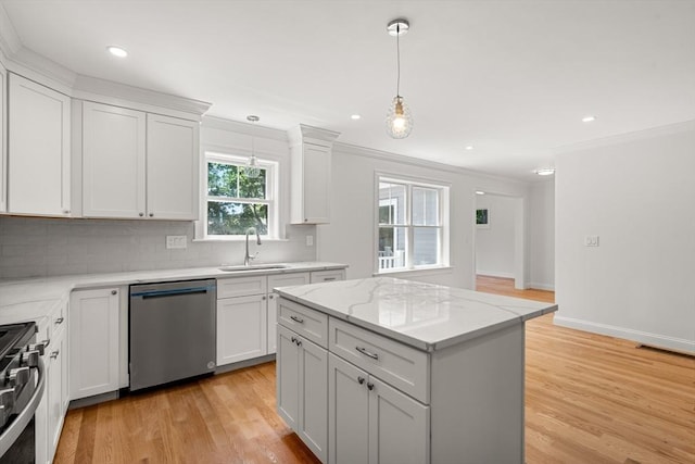 13 River Unit 2, Danvers, MA 01923 - kitchen featuring appliances with stainless steel finishes, crown molding, backsplash, light wood finished floors, and decorative light fixtures