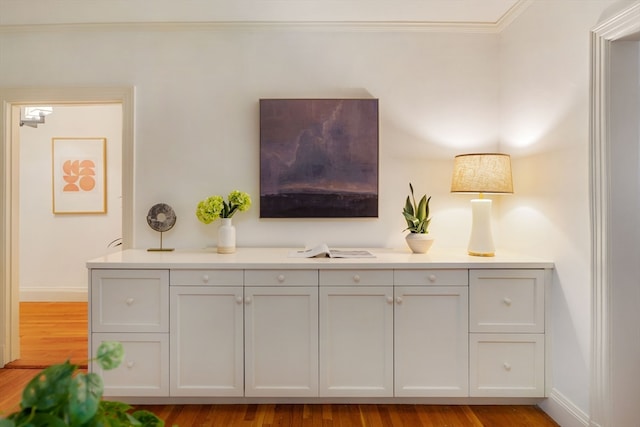 interior space with ornamental molding and hardwood / wood-style floors