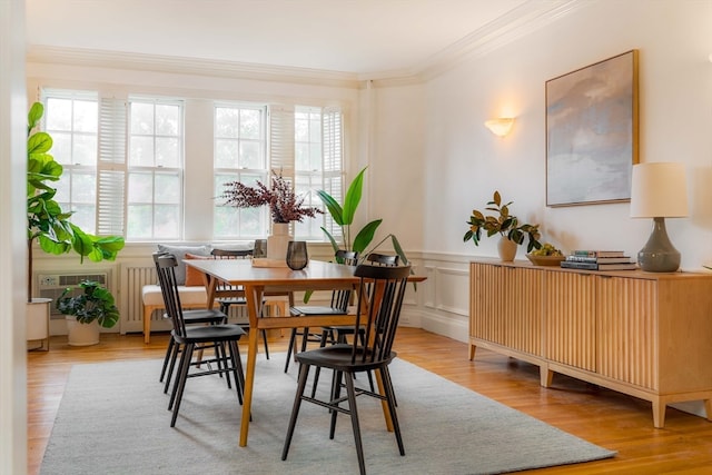 dining space with light wood-type flooring and crown molding