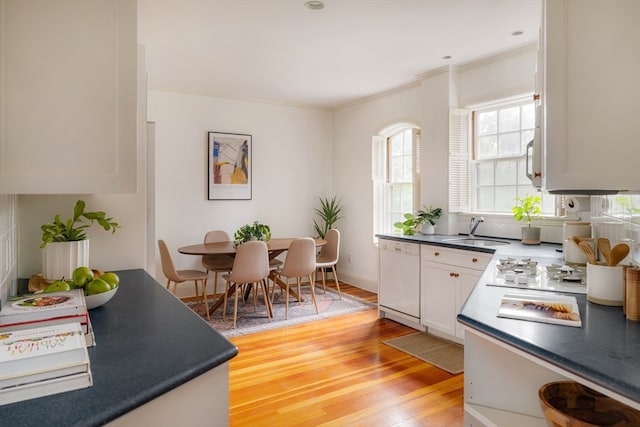 kitchen with dishwasher, sink, white cabinets, light hardwood / wood-style flooring, and ornamental molding