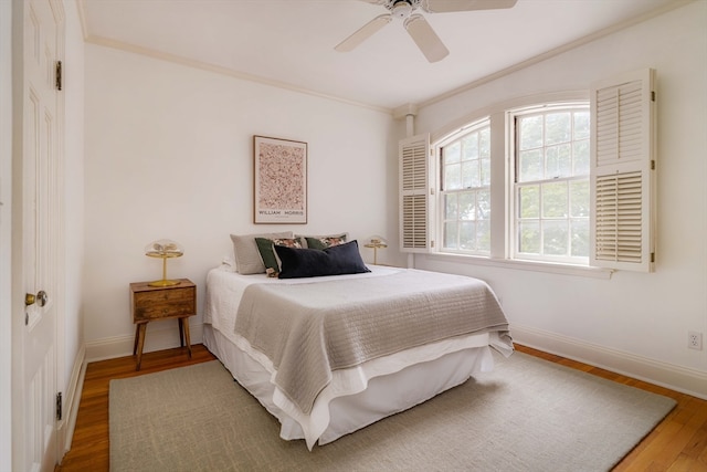 bedroom with ceiling fan, hardwood / wood-style flooring, and crown molding