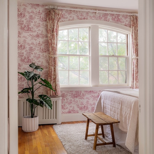 sitting room with hardwood / wood-style floors, radiator heating unit, and plenty of natural light