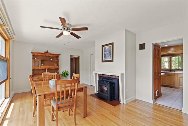 10 Powderhouse Cir, Wilmington, MA 01887 - dining room with a wood stove, a ceiling fan, light wood-style flooring, and baseboards