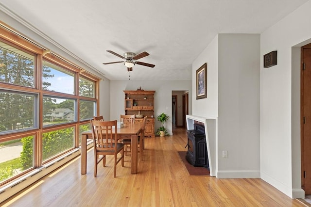 10 Powderhouse Cir, Wilmington, MA 01887 - dining room with a wood stove, ceiling fan, light wood-style flooring, and baseboards