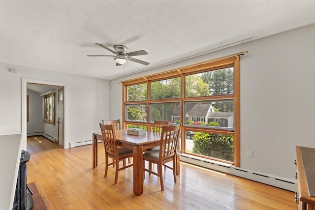10 Powderhouse Cir, Wilmington, MA 01887 - dining area with baseboard heating, ceiling fan, light wood-style floors, and a baseboard radiator