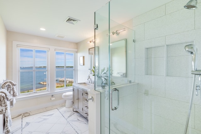 bathroom with vanity, a shower with shower door, toilet, and a water view