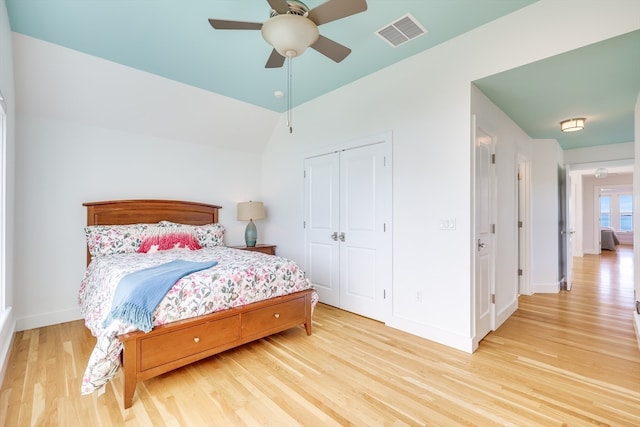 bedroom featuring ceiling fan, light hardwood / wood-style flooring, a closet, and lofted ceiling