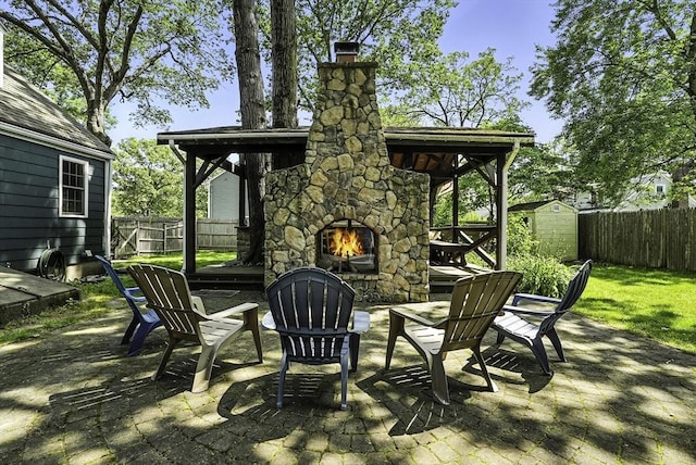 7 Vermont Ave, Natick, MA 01760 - fenced backyard featuring an outdoor stone fireplace, a patio, and a storage shed
