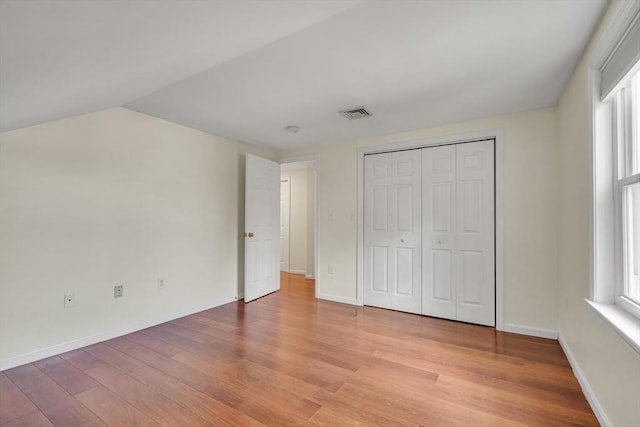 17-1 Parkers Ln Unit 1, Waltham, MA 02453 - unfurnished bedroom with light wood finished floors, multiple windows, baseboards, and vaulted ceiling