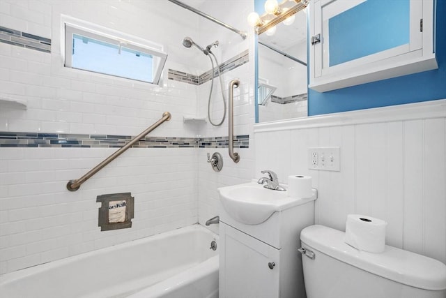 full bathroom featuring vanity, toilet, shower / washtub combination, and a wainscoted wall
