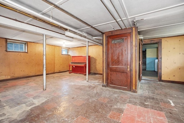 below grade area featuring wooden walls and baseboards