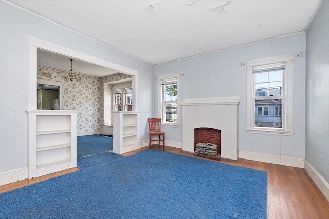 living area featuring wood-type flooring, baseboards, ornamental molding, and a fireplace