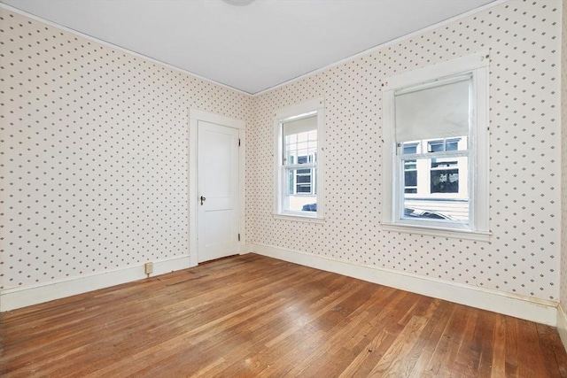 spare room with baseboards, ornamental molding, and hardwood / wood-style flooring