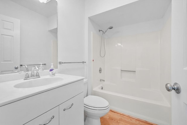 full bathroom with hardwood / wood-style flooring, vanity, shower / bathtub combination, and toilet