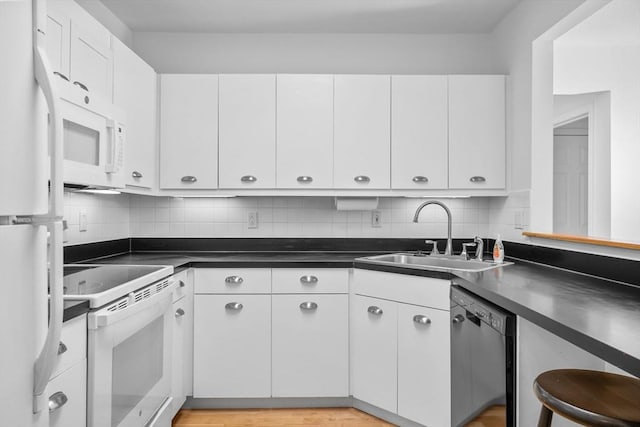 kitchen featuring backsplash, white cabinetry, sink, and white appliances