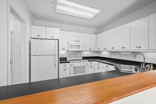 kitchen with tasteful backsplash, white cabinetry, sink, and white appliances