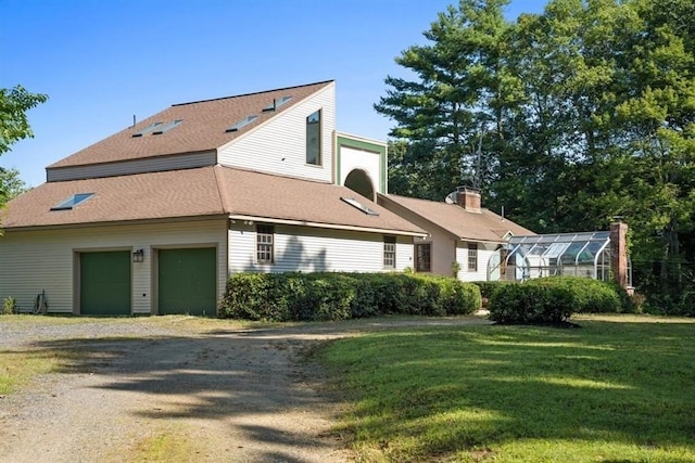 view of side of home featuring a yard, an attached garage, and dirt driveway