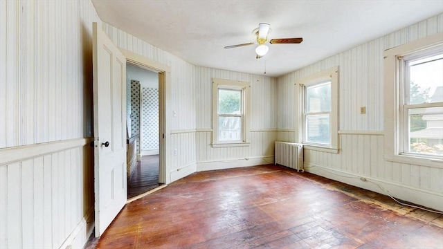 11 Quincy Ave, Norwood, MA 02062 - unfurnished room with radiator heating unit, wallpapered walls, hardwood / wood-style flooring, and ceiling fan