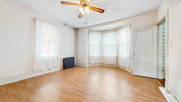 11 Quincy Ave, Norwood, MA 02062 - spare room with radiator, wallpapered walls, wood finished floors, healthy amount of natural light, and a ceiling fan