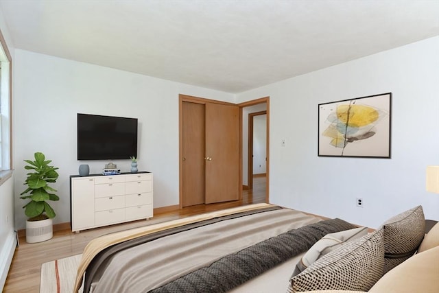 bedroom featuring light wood finished floors and baseboards