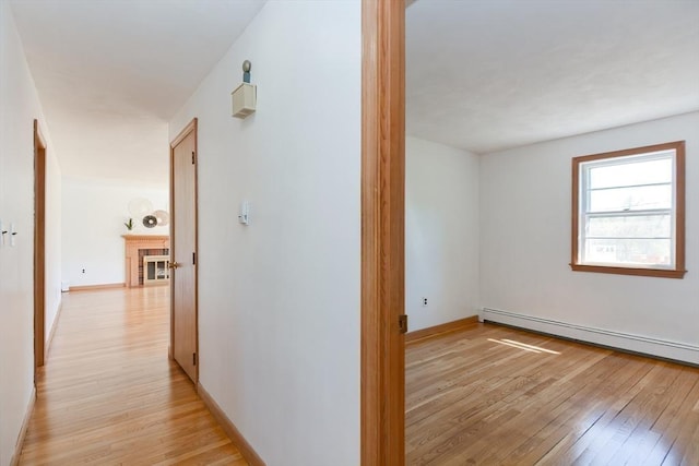 hallway featuring baseboards and light wood-style flooring