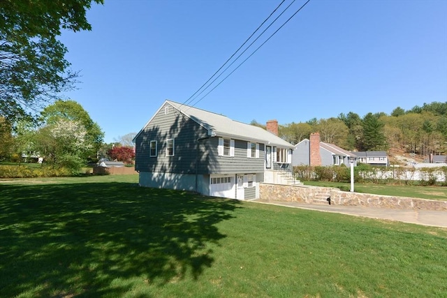 view of side of home with a yard and a chimney