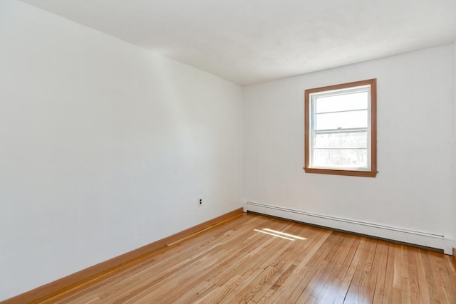 empty room with baseboards, a baseboard radiator, and light wood-style flooring
