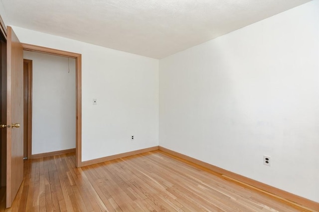 unfurnished room featuring light wood finished floors and baseboards
