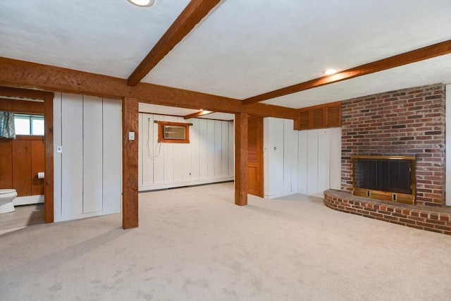 unfurnished living room featuring carpet flooring, beam ceiling, a brick fireplace, wood walls, and a wall mounted AC