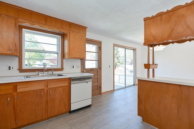 kitchen featuring dishwasher, brown cabinets, and a sink