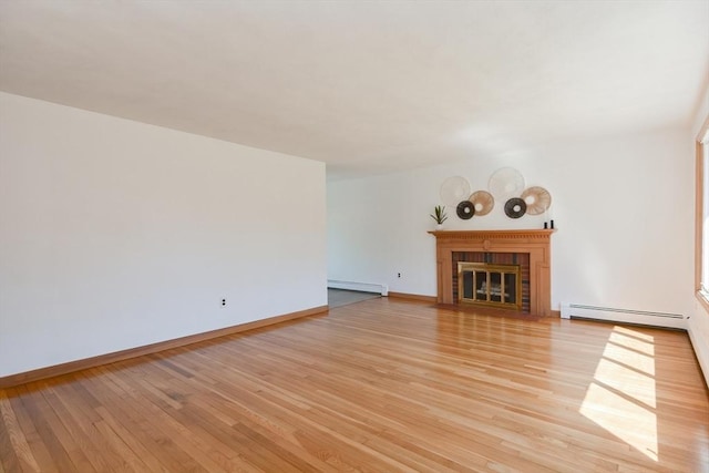 unfurnished living room featuring a baseboard radiator, a fireplace with flush hearth, baseboard heating, and light wood-style floors