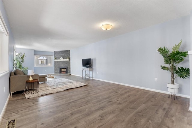 unfurnished living room with wood-type flooring and a large fireplace