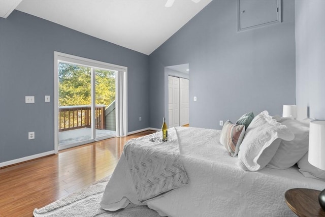 bedroom featuring wood-type flooring, high vaulted ceiling, a closet, and access to outside