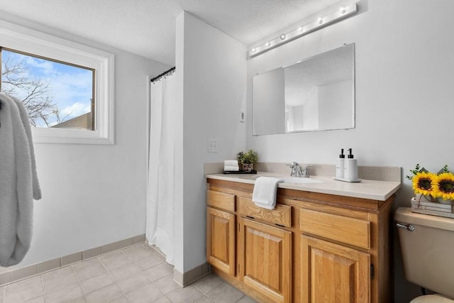 bathroom featuring vanity, walk in shower, toilet, tile patterned floors, and a textured ceiling