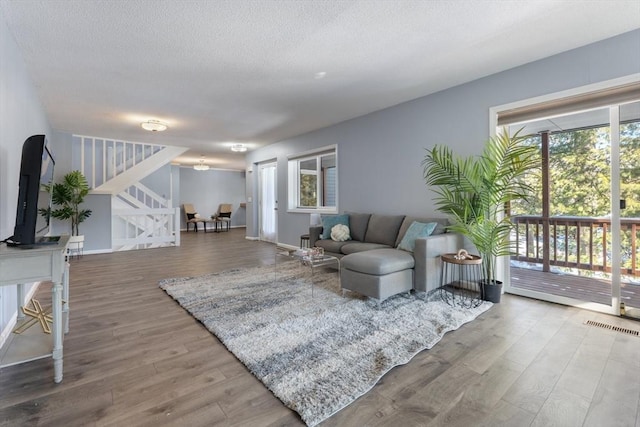 living room with hardwood / wood-style flooring and a textured ceiling