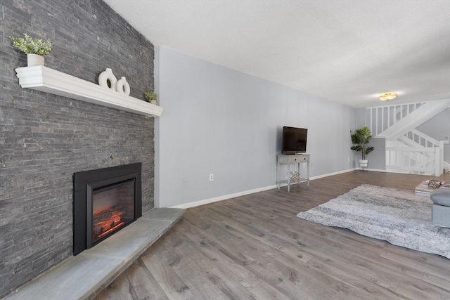 living room with wood-type flooring and a large fireplace